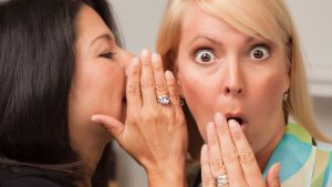 A lady is telling secrets and the other lady is surprised by the secret.
